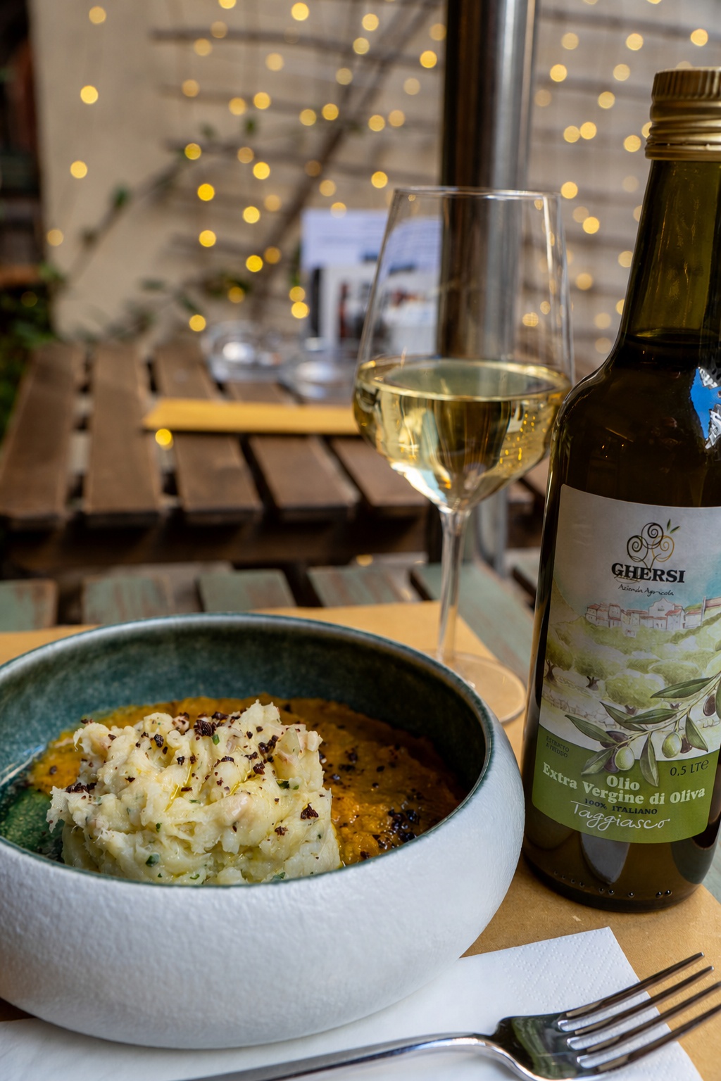 Un piatto della cucina accompagnato da vino e olio taggiasco